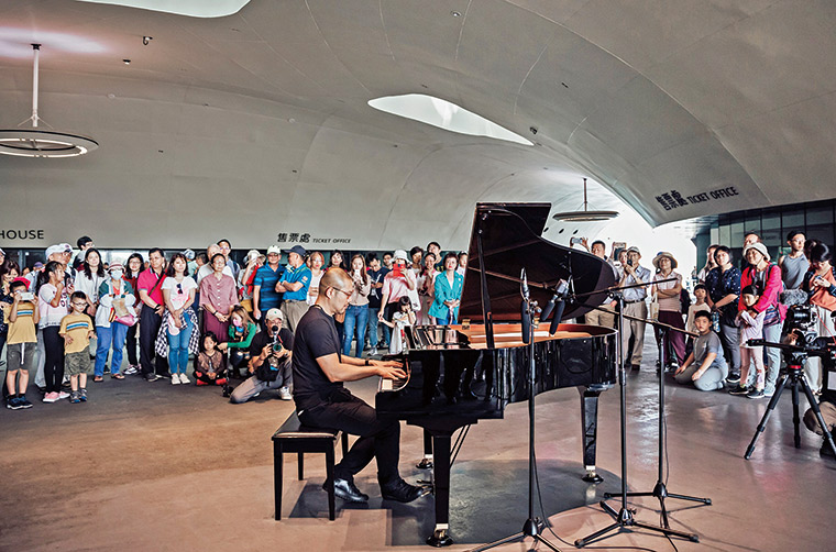 衛武營在榕樹廣場設置「公共鋼琴」，歡迎任何人來彈奏，期盼 藝術走進眾人生活。圖為鋼琴啟用時，簡文彬親自下場秀一手。