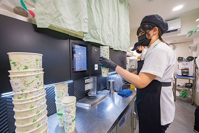 黑 色機體的AI製茶 機體積 龐大，可定溫存 放約10桶基礎液 體。