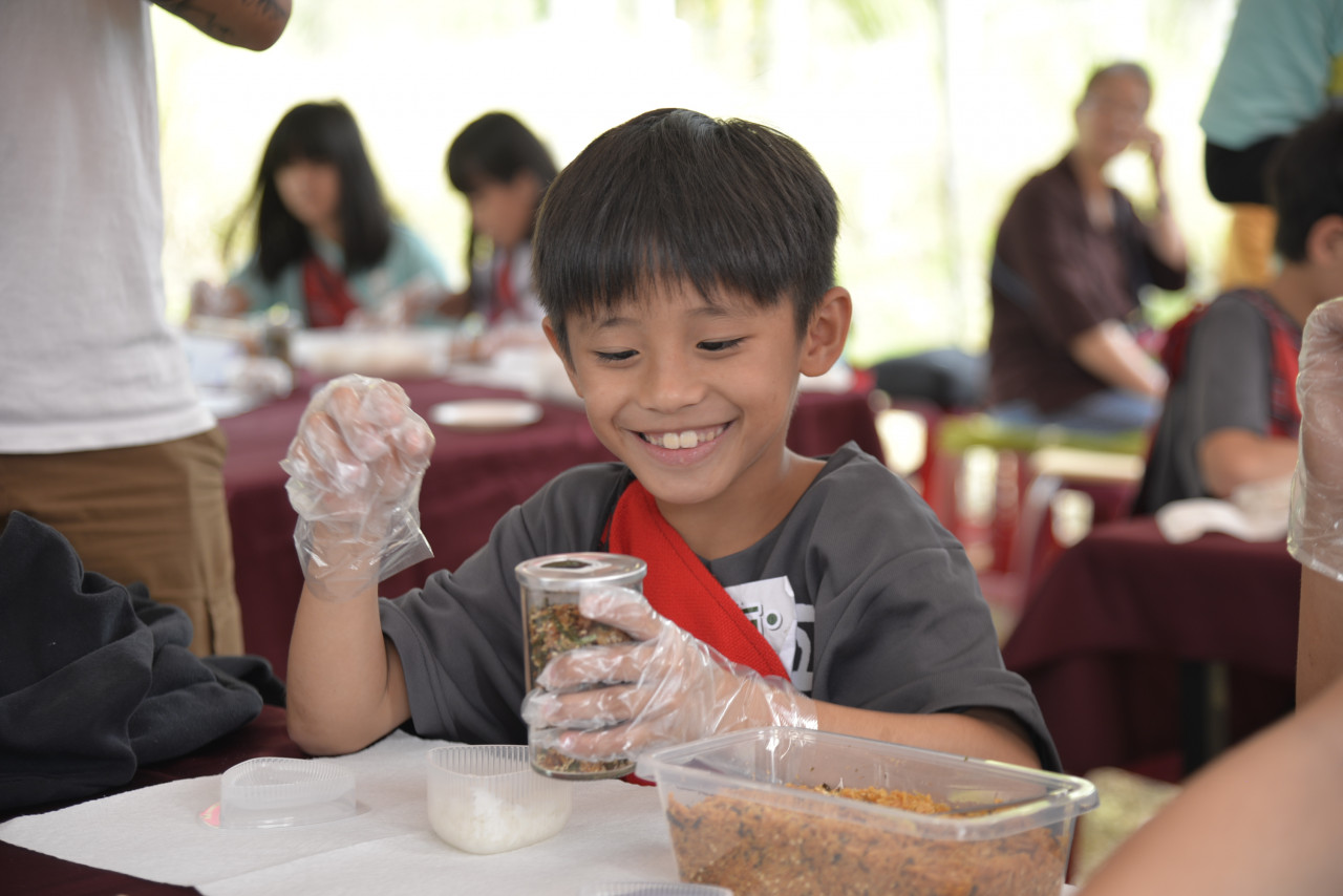 原鄉南投縣互助國小孩童，親自將減藥後的川中米包成飯糰，品嘗成果。