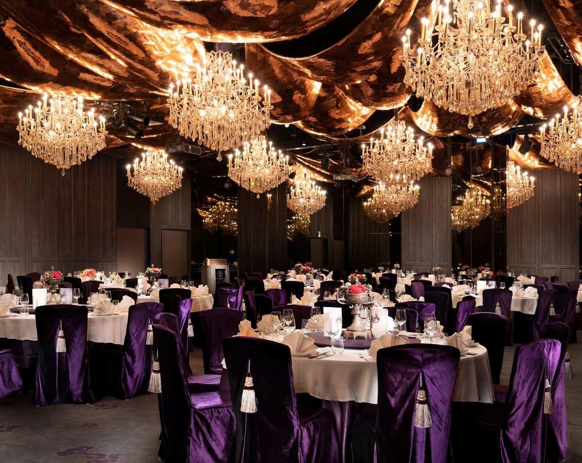 圖2 君品酒店中「亮」廳有5米挑高大廳，天花板以宛若歌劇院布幕垂墜的金屬材質打造，配上16盞水晶燈映出古典法國情調，適合大型宴會、各類型的展演活動。_雲品國際提供